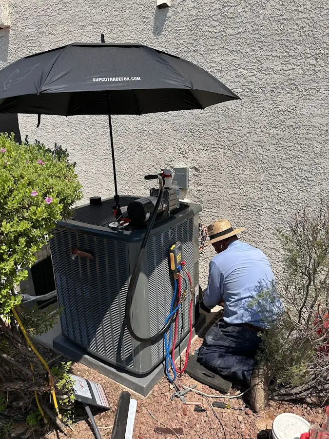HVAC technician performing outdoor AC maintenance in Alamo