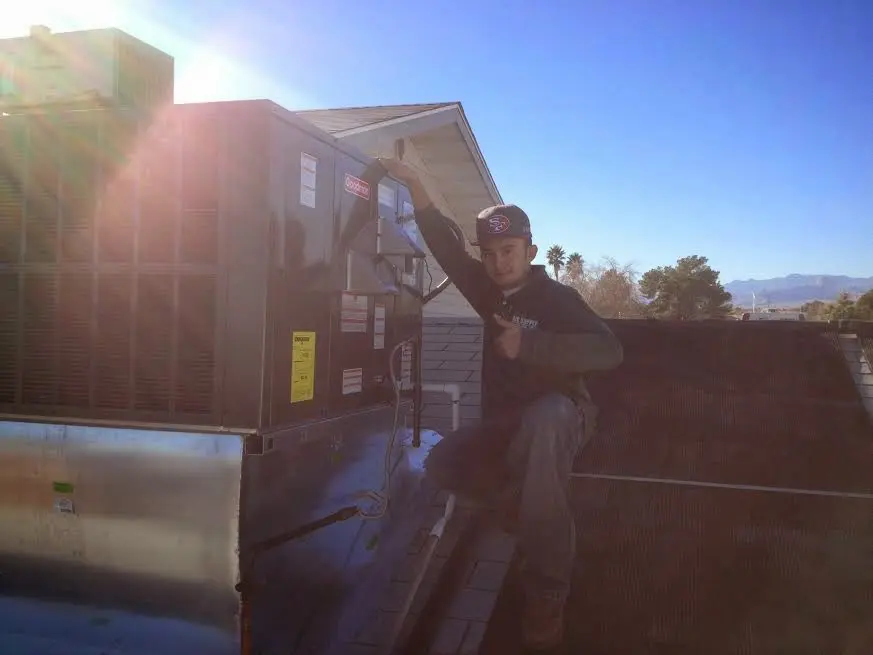 HVAC technician performing AC Tune-Up on a rooftop unit in Alamo